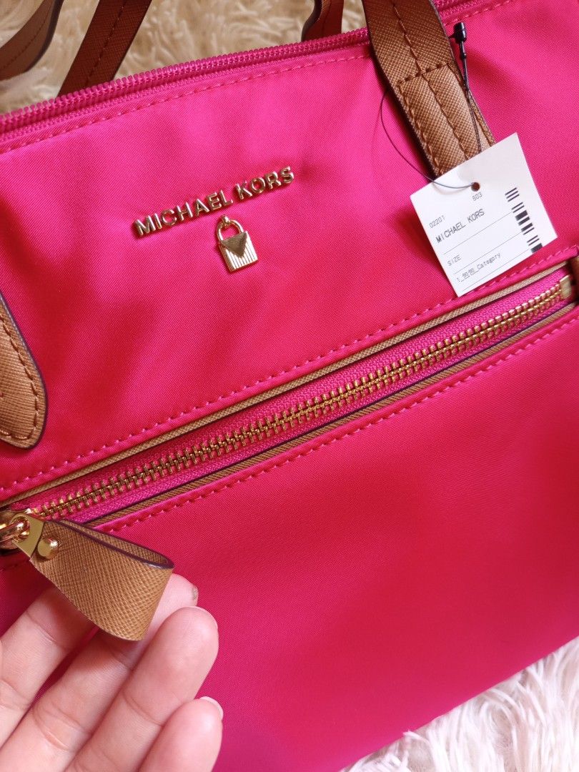 Michael Kors Pink Tote Bag (Category: Luxury Bags & Wallets) located in Iloilo. Submitted by cezminishop (Listing ID 1434414822, Image 3). Description: - Authentic Michael Kors tote bag - Vibrant pink color - Front zip pocket - Gold-tone hardware - Dual top handles with brown accents - Includes original tags and care card - Interior: zip pocket and slip pocket - Protective metal feet at the bottom -Personally bought in Taiwan -Original price NT$6