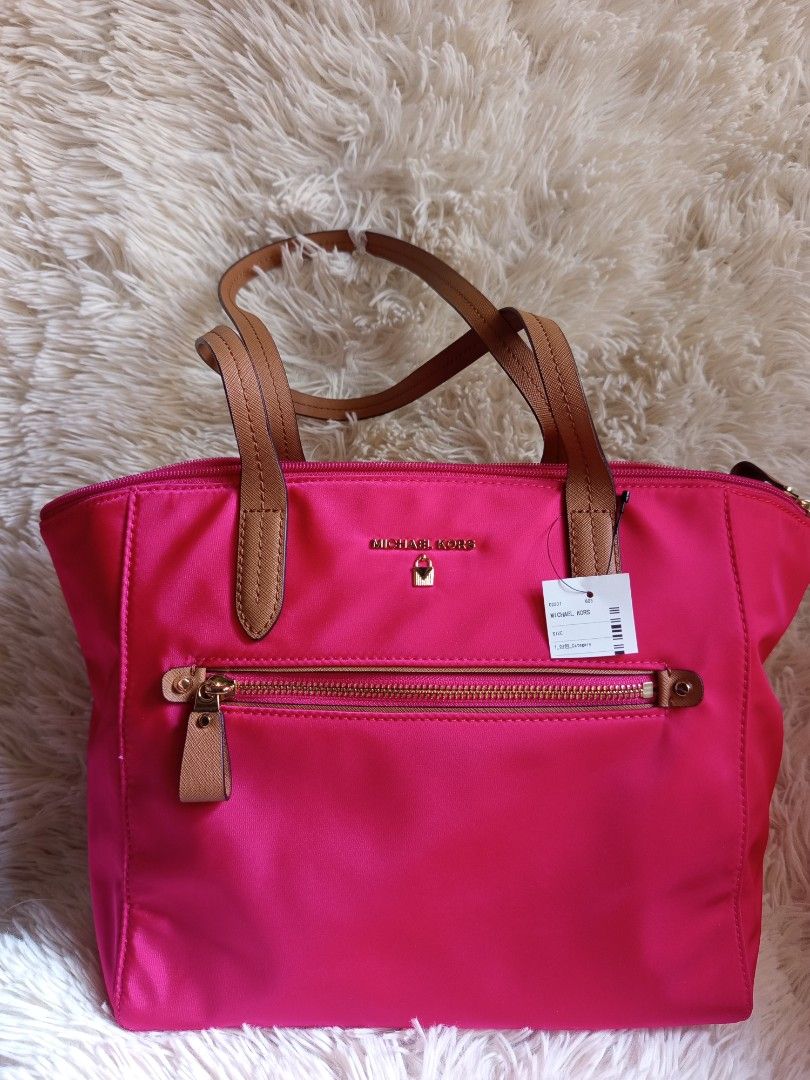 Michael Kors Pink Tote Bag (Category: Luxury Bags & Wallets) located in Iloilo. Submitted by cezminishop (Listing ID 1434414822, Image 1). Description: - Authentic Michael Kors tote bag - Vibrant pink color - Front zip pocket - Gold-tone hardware - Dual top handles with brown accents - Includes original tags and care card - Interior: zip pocket and slip pocket - Protective metal feet at the bottom -Personally bought in Taiwan -Original price NT$6