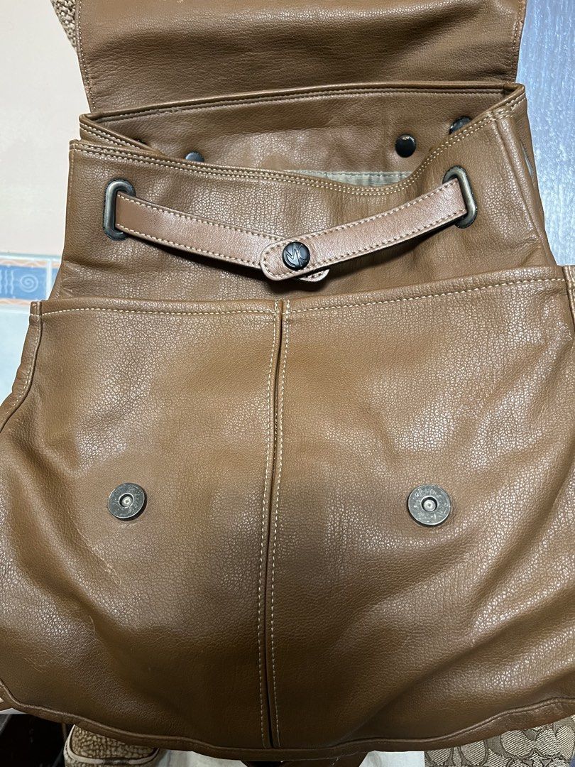 Michiko London Koshino Leather Backpack (Category: Backpacks) located in Los Banos. Submitted by profemy (Listing ID 1434447809, Image 2). Description: - Brown leather backpack by Michiko London Koshino - Flap closure - Top handle - Adjustable straps - Interior zippered pocket - Textured leather exterior - Fabric lining - Brand label inside Authentic Michiko London Koshino. Genuine lesther. Malambot ang pagka-leather. May 2 front open pockets na 