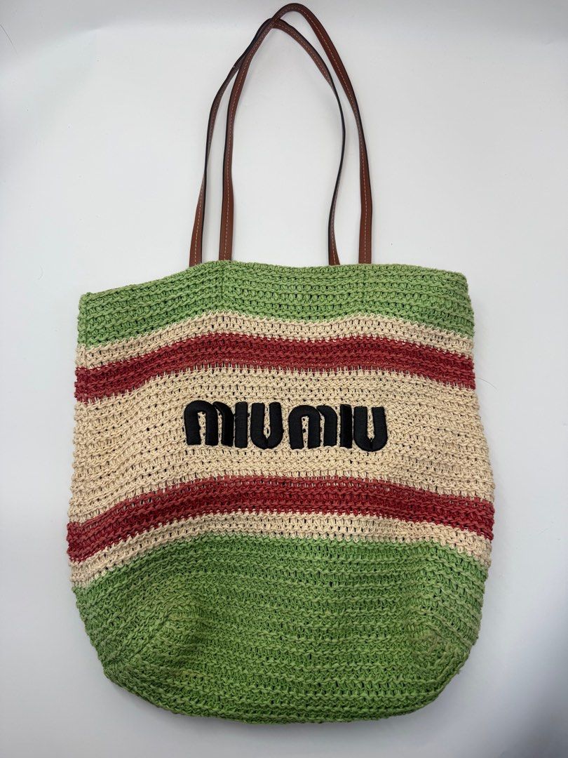 Miu Miu Tote Bag (Category: Luxury Bags & Wallets) located in Caloocan City. Submitted by rossvault2 (Listing ID 1434459596, Image 1). Description: Miu Miu tote bag features a woven straw design with green, beige, and red stripes. It has brown leather handles and a green interior with a zippered pocket. The Miu Miu logo is prominently displayed on the front. Ykk zip Normal signs of use, Ukay, please manage ur expectations.