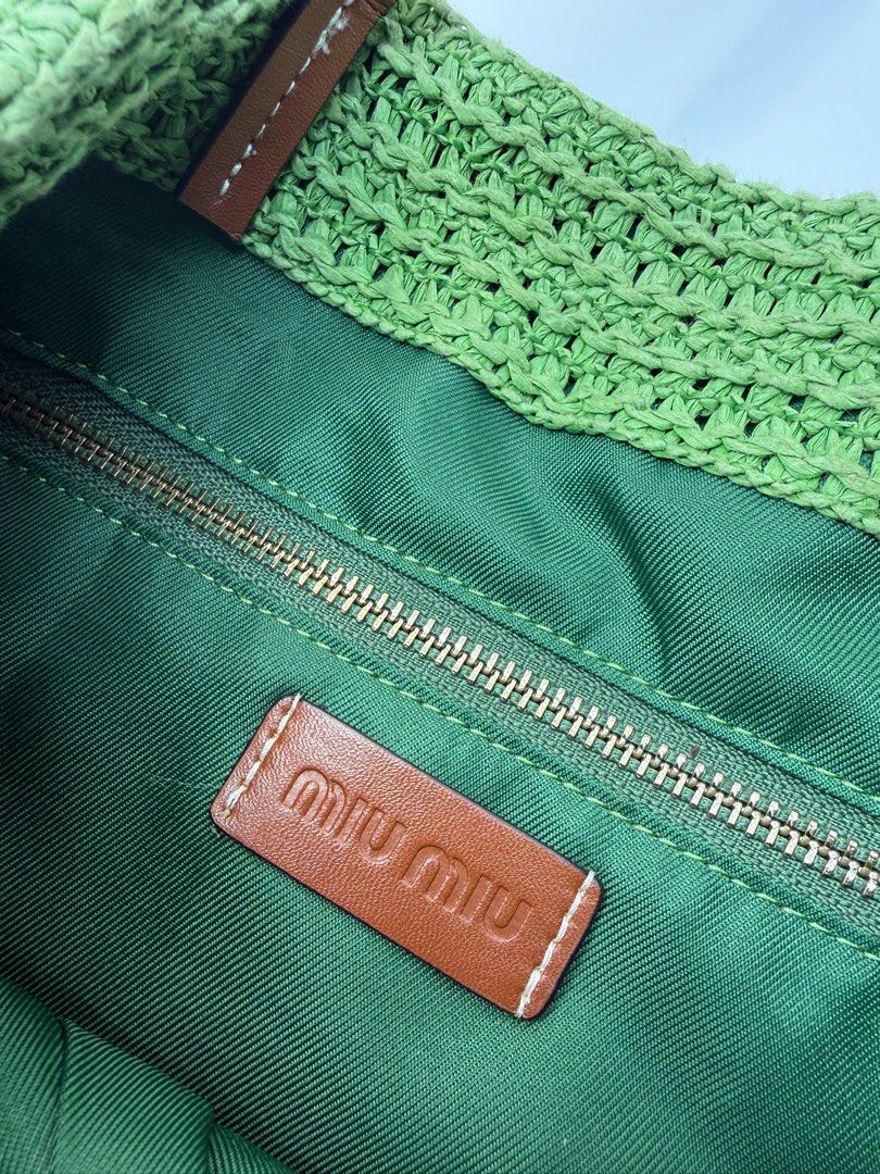 Miu Miu Tote Bag (Category: Luxury Bags & Wallets) located in Caloocan City. Submitted by rossvault2 (Listing ID 1434459596, Image 3). Description: Miu Miu tote bag features a woven straw design with green, beige, and red stripes. It has brown leather handles and a green interior with a zippered pocket. The Miu Miu logo is prominently displayed on the front. Ykk zip Normal signs of use, Ukay, please manage ur expectations.