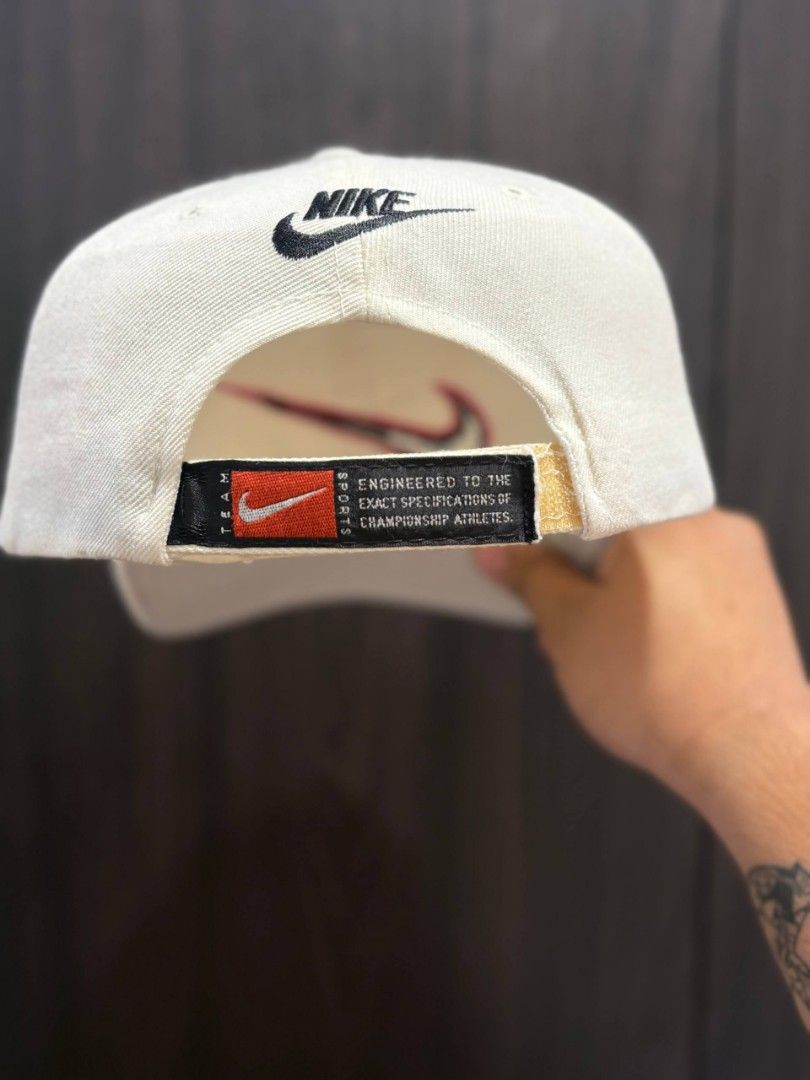 Vintage Nike Cap (Category: Caps & Hats) located in Quezon City. Submitted by trellzilla666 (Listing ID 1434527275, Image 3). Description: - Cream-colored Nike cap - NBA logo on the side - Red and black Nike swoosh on the front - Nike logo on the back - Tagline: "Engineered to the exact specifications of championship athletes.".