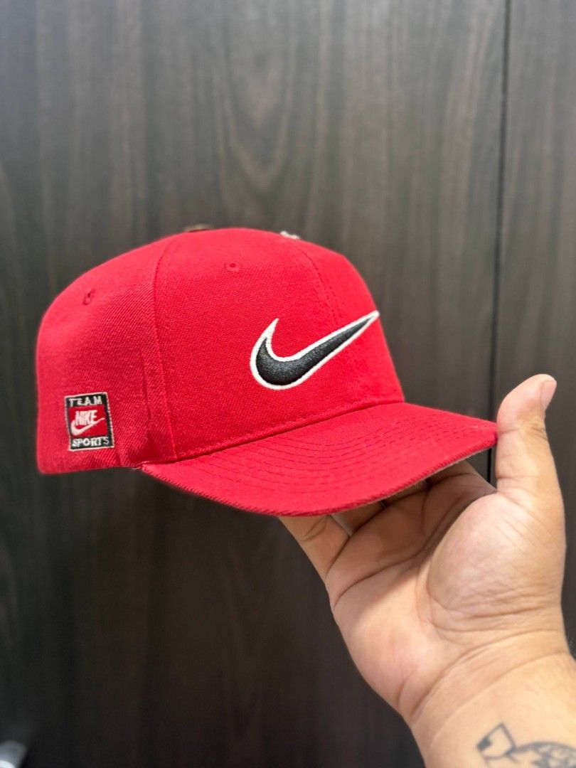 Vintage Nike Cap (Category: Caps & Hats) located in Quezon City. Submitted by trellzilla666 (Listing ID 1434527279, Image 1). Description: - Red Nike cap - Black swoosh logo - "Team Nike Sports" patch - Nike logo on the back - Flat brim - Adjustable strap - Red interior with white Nike logo.