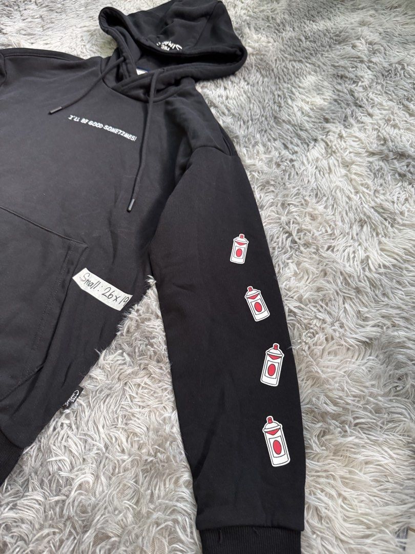 The Simpsons Ben Sherman Hoodie (Category: Coats, Jackets and Outerwear) located in Lila. Submitted by jkorapparel008 (Listing ID 1434544354, Image 3). Description: - Black hoodie with The Simpsons and Ben Sherman branding. - Features a front pocket and a hood with a drawstring. - Left sleeve: Spray paint can graphics. - Right sleeve: Target logo. - Back: Bart Simpson graphic with "EL BARTO WAS HERE" text. - Front: "I'LL BE GOOD SOMETIMES!" text.