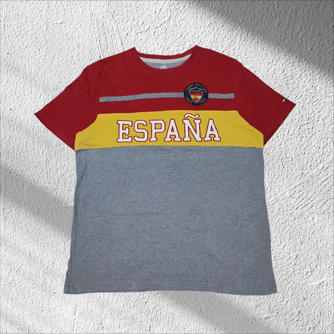 Tommy Hilfiger España Graphic Tee (Category: Tshirts & Polo Shirts ) located in Manila. Submitted by anthonig (Listing ID 1434471046, Image 1). Description: •Length: 27.5inches •Width: 21 inches •Condition: 9.5/10 •Issue: 3rd photo - Tommy Hilfiger t-shirt - Size: M - Design: Color block with 'España' across the front - Features: Crew neck, short sleeves - Details: Tommy Hilfiger logo patch with 'España' and Spanish flag.