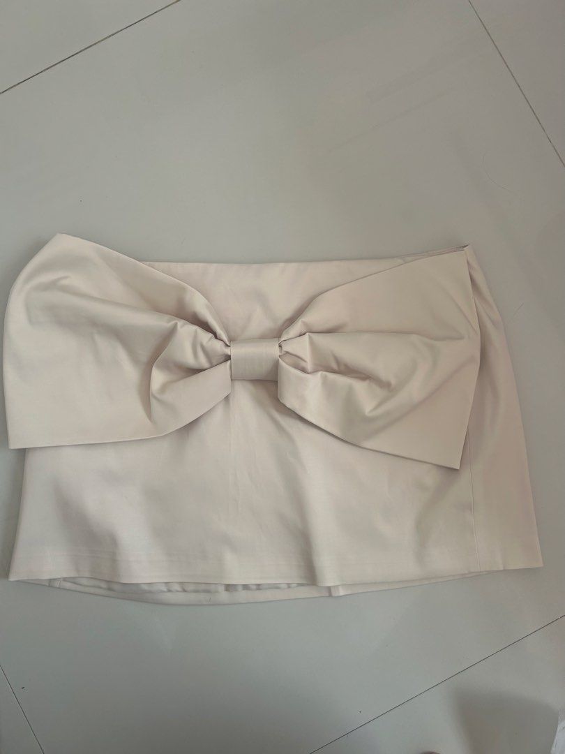 Zara Bow Detail Skirt (Category: Skirts) located in Pulilan. Submitted by yaokow_ (Listing ID 1434391414, Image 1). Description: - Zara cream mini skirt - Features a large bow detail - Size: XL never used just removed the tag before cuz akala ko magagamit ko one time but hindi pala.