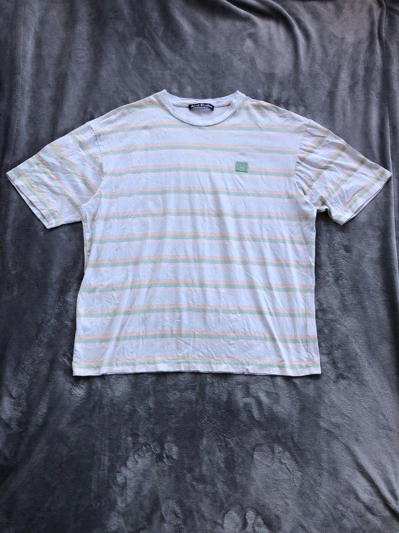 Acne Studios Striped T-shirt (Category: Tshirts & Polo Shirts ) located in Manila. Submitted by niggzreyno51476 (Listing ID 1434642667, Image 1). Description: - Acne Studios striped t-shirt - Crew neck design - Features a small square face logo patch - Horizontal stripes in white, green, and orange - Brand label visible on the inside collar - Includes brand tag with washing instructions - New with tags.
