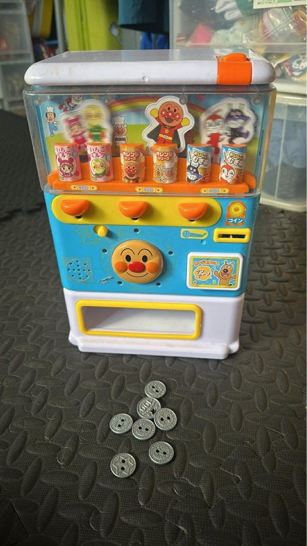 Anpanman Juice Vending Machine Toy (Category: Designer & Blind Box Toys) located in Cainta. Submitted by shopbyyna (Listing ID 1434743476, Image 1). Description: - Anpanman-themed juice vending machine toy. - Includes toy juice cups and play coins. - Features a clear top section for juice display. - Has a coin slot and dispensing area. - Made by JoyPalette. - Made in China..