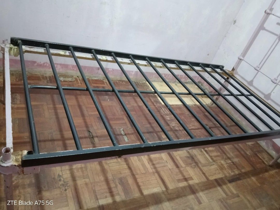 Antique Metal Bed Frame (Category: Bed Frames & Mattresses) located in Lucena. Submitted by miles.miles1 (Listing ID 1434627623, Image 2). Description: - Antique metal bed frame - Fits a single mattress - Dimensions: - Length: 78 inches - Width: 35 inches - Head Height: 47 inches - Bed Height: 16 inches - Features a metal grid for mattress support - Painted in a light color - Antique design.
