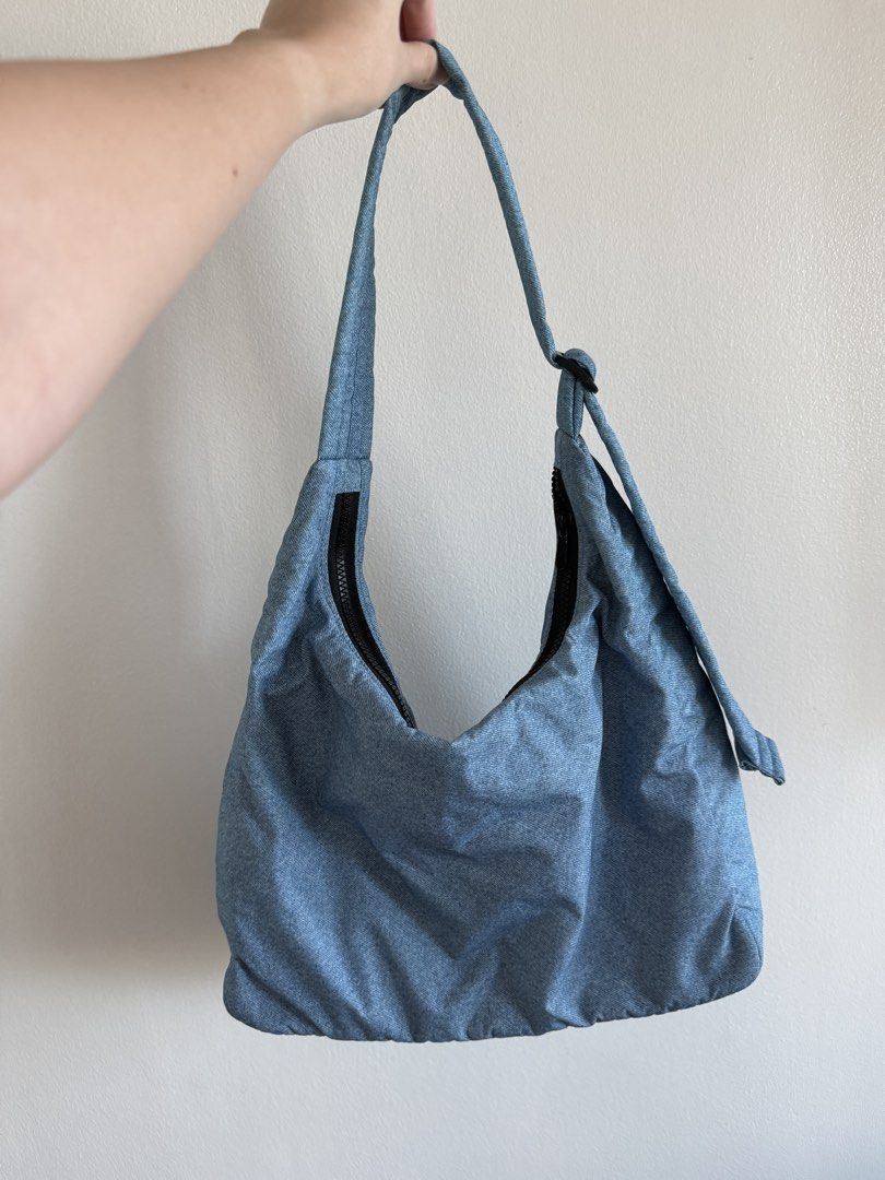 Baggu Nylon Shoulder Bag (Category: Shoulder Bags) located in Makati City. Submitted by clothesilovedx (Listing ID 1434613256, Image 1). Description: - Light blue denim-like material - Zip closure - Interior pocket - Machine washable Dimensions: 27.5" adjustable quilted strap 10.5" H x 14" W x 4" L.