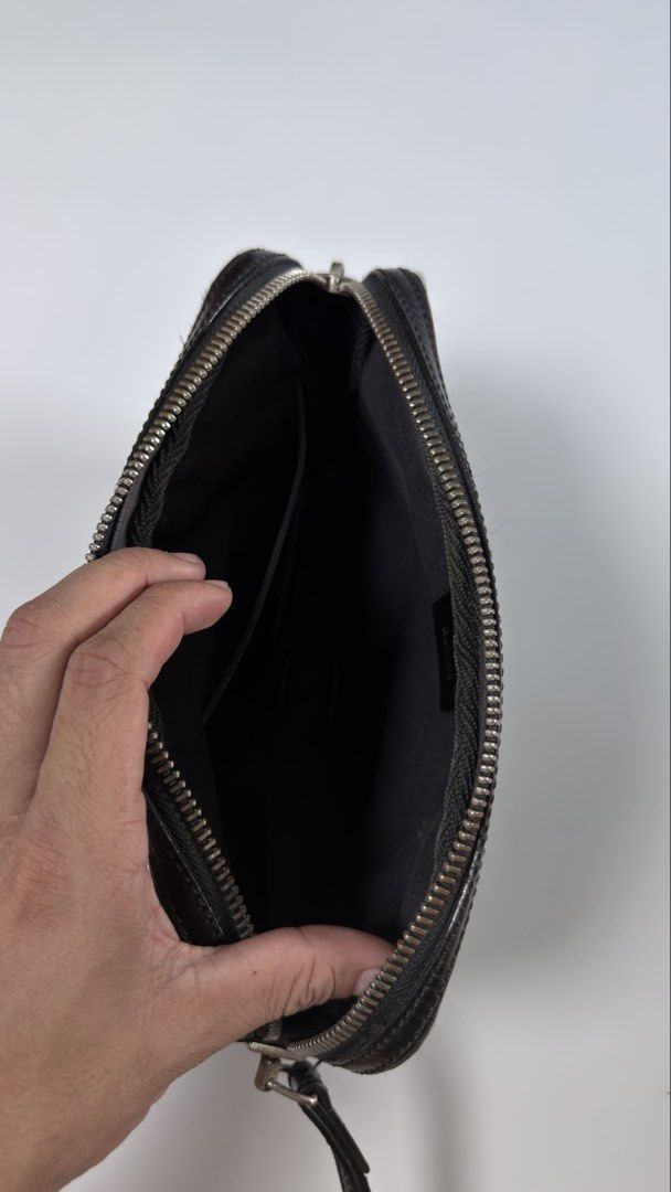 Bally Black Clutch Bag (Category: Luxury Bags & Wallets) located in Alfonso. Submitted by jbcamet (Listing ID 1434732916, Image 3). Description: Black clutch bag by Bally. Features a zip closure and a wrist strap. The interior includes a small pocket and a brand label. The bag is made in Spain. The exterior has a subtle pattern. The zipper has a Bally logo on the pull..