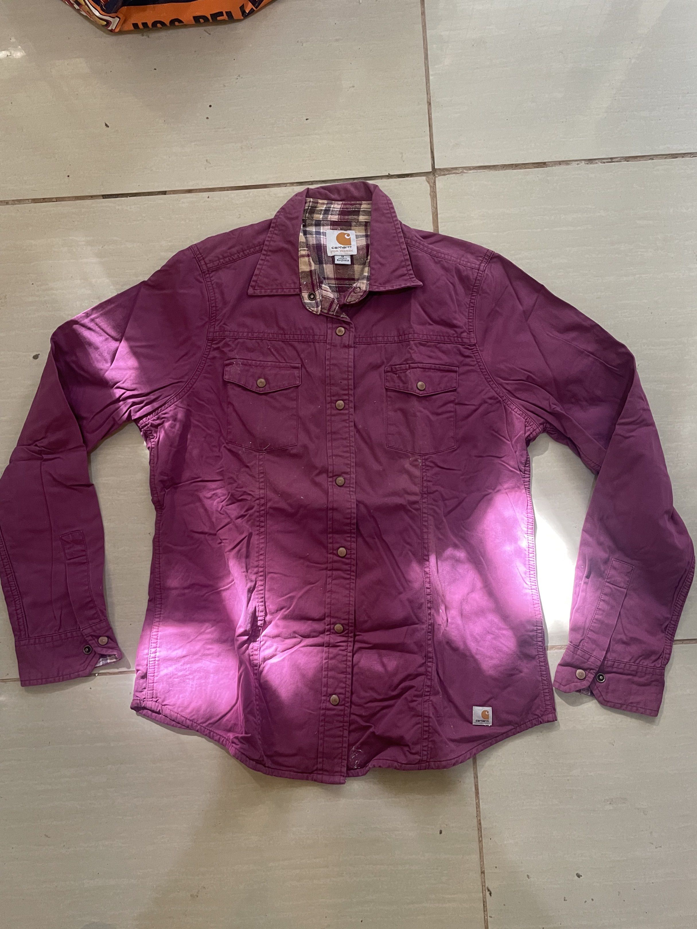 Carhartt For Women Shirt (Category: Shirts) located in Santa Barbara. Submitted by frryt (Listing ID 1434603292, Image 1). Description: - Carhartt women's button-down shirt - Features two chest pockets - Stylish plaid lining on collar and inside - Deep purple color - Size: Medium - Made in Bangladesh.