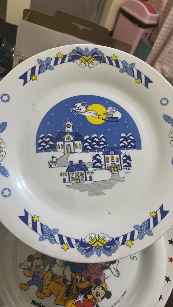 Christmas Plate with Village Scene (Category: Other Home Decor) located in Mandaluyong City. Submitted by chmrxx (Listing ID 1434744082, Image 1). Description: - Vintage Christmas plate. - Features a charming Christmas village scene. - Includes a church, houses, and a snowman. - Decorated with blue ribbons, stars, and bells. - White plate with colorful illustration. - Ideal for holiday decor or collecting..