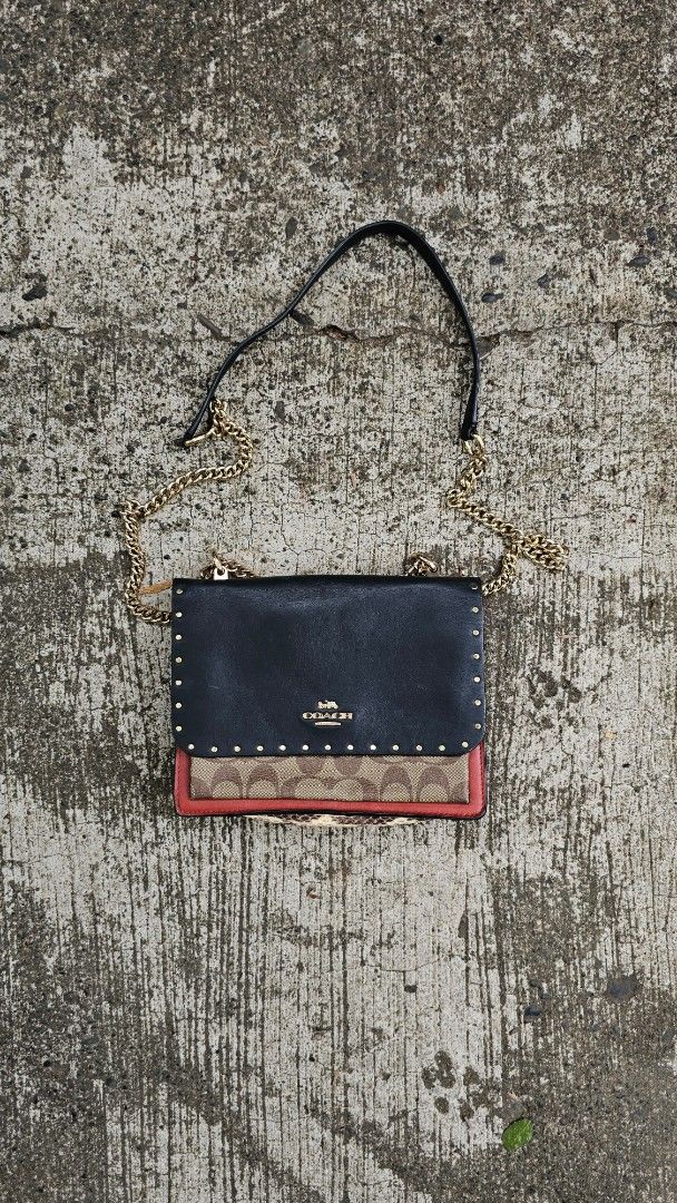Coach Clutch with Chain Strap (Category: Luxury Bags & Wallets) located in Kibawe. Submitted by Thrift_ni_Babac (Listing ID 1434660390, Image 1). Description: - Authentic Coach clutch - Black exterior with gold-tone studs - Chain strap included - Interior with multiple compartments - Brown lining - Zipper closure - Made in Vietnam - Coach logo visible See last two photo for issue.