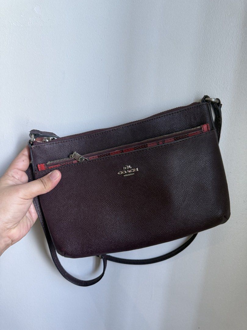 Coach Crossbody Bag with Plaid Interior (Category: Luxury Bags & Wallets) located in Makati City. Submitted by prelovedbydrjen (Listing ID 1434632276, Image 1). Description: - Authentic Coach crossbody bag - Deep burgundy exterior - Stylish plaid interior - Multiple zippered compartments for organization - Long strap for shoulder or crossbody wear - Features the Coach logo - Crafted from textured leather.