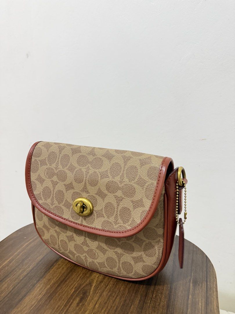 Coach Signature Crossbody Bag (Category: Luxury Bags & Wallets) located in Dasmarinas. Submitted by lovekayeeeee (Listing ID 1434705120, Image 3). Description: Coach crossbody bag with signature pattern. Features a top flap with a clasp closure. Includes a detachable striped shoulder strap and a leather tag. The interior has a zippered pocket. The bag has brown leather trim and gold-tone hardware..