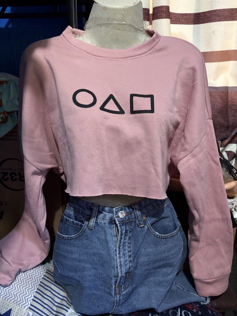 Crop Top Pull Over - All for 100 (Category: Others Tops) located in Quezon City. Submitted by ddpreloveditems (Listing ID 1434804411, Image 2). Description: - Crop top pullovers - Colors: Beige, pink, orange, black - Designs: Squid Game symbol, smiley face - Price: 100 pesos - Perfect for casual wear.