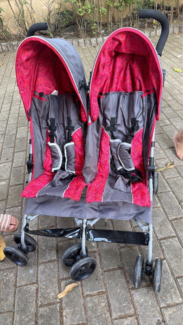 Delta Children Double Stroller (Category: Strollers) located in Paranaque City. Submitted by beagarciachoy (Listing ID 1434636764, Image 2). Description: - Double stroller with two seats and canopies - Features: - Cup holder - Storage - Color schemes: - Navy blue and teal - Gray and pink - Foldable design for easy storage and transport.
