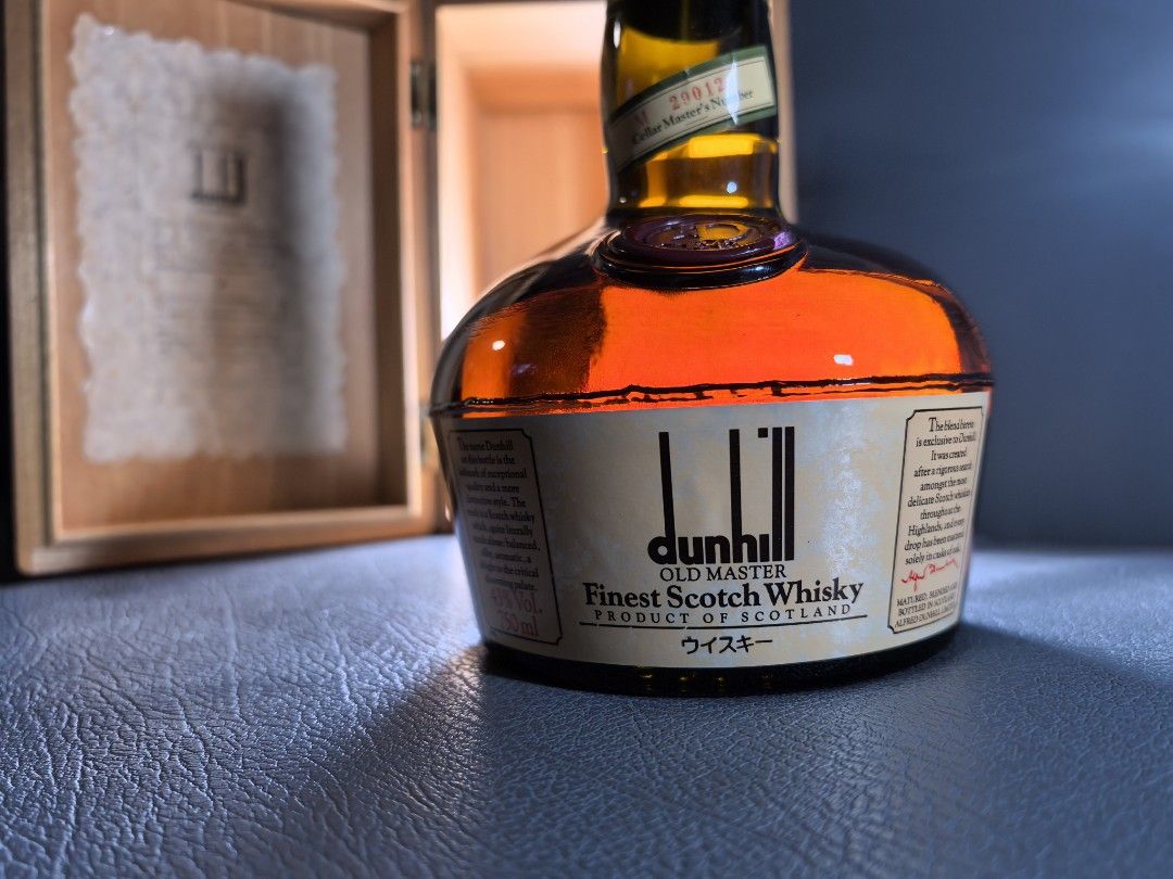 Dunhill Old Master Finest Scotch Whisky (Category: Beverages) located in Cagayan de Oro. Submitted by pootx (Listing ID 1434749504, Image 2). Description: - Vintage Dunhill Old Master Finest Scotch Whisky - Original wooden box with gold trim and Dunhill logo - Distinctive black bottle design with Dunhill label - Includes original paper insert - Cellar Master's Number: M 29012.