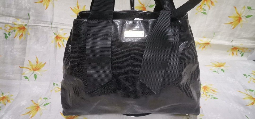 KATE SPADE BLACK Bow Top Handle Handbag (Category: Luxury Bags & Wallets) located in Baguio. Submitted by blossombeauty.chicfinds23 (Listing ID 1434675897, Image 2). Description: - Black Kate Spade handbag - Bow detail - Textured exterior - Polka dot interior lining - Interior zippered pocket - Top handle design - Rectangular shape - Metal feet at the bottom.