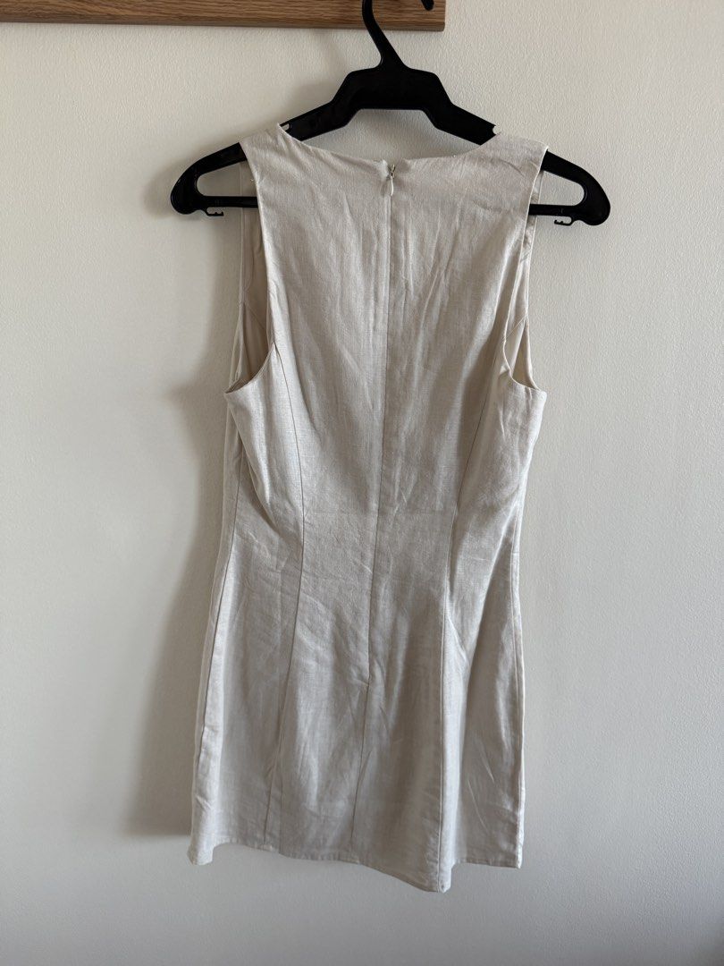 Mango Linen Mini Dress - XS (Category: Dresses) located in Makati City. Submitted by clothesilovedx (Listing ID 1434613657, Image 2). Description: - Mango mini dress - Color: Beige - Size: XS - V-neckline with tie detail - Sleeveless - Fabric: Linen - Back zipper closure - Suitable for casual and semi-formal events.
