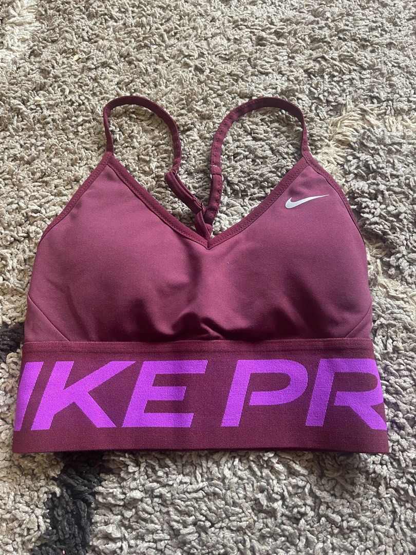 Nike Pro Sports Bra (Category: Activewear) located in La Trinidad. Submitted by avessonjam (Listing ID 1434716714, Image 2). Description: - Nike Pro sports bra - Burgundy color with purple "NIKE PRO" band - Racerback design - Thin straps - Nike logo on front - Made of stretchy material.