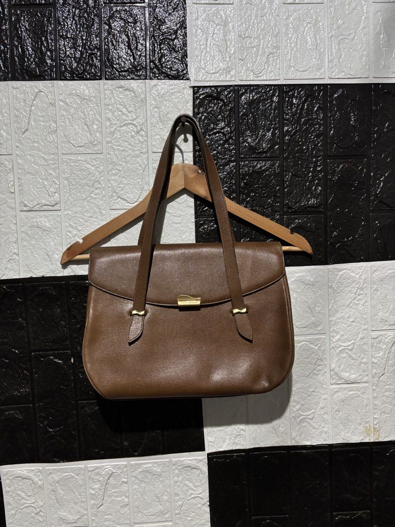 Pierre Balmain Brown Leather Handbag (Category: Luxury Bags & Wallets) located in Lopez. Submitted by thrift.ni.roms22 (Listing ID 1434656001, Image 1). Description: Elegant Pierre Balmain handbag in a rich brown color. Features a classic design with a flap closure and gold-tone hardware. The bag has double top handles and a spacious interior. The interior includes multiple compartments for organization. Dimensions are approximately 13W x 10L. Th