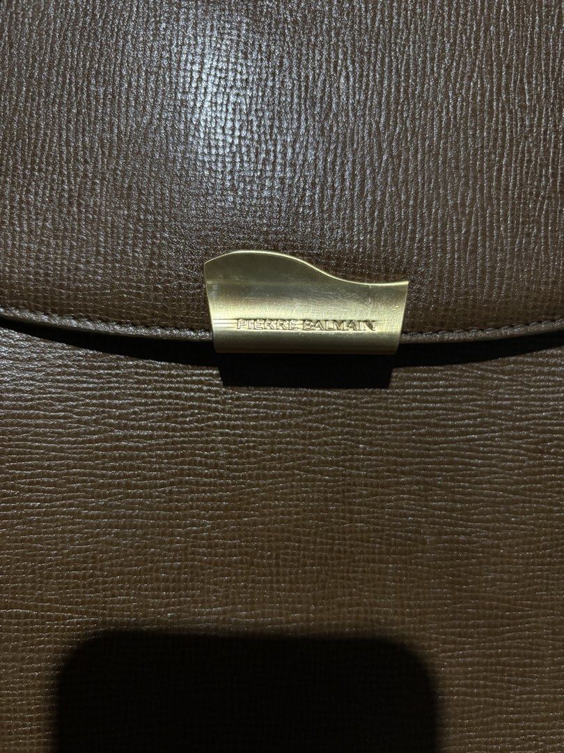 Pierre Balmain Brown Leather Handbag (Category: Luxury Bags & Wallets) located in Lopez. Submitted by thrift.ni.roms22 (Listing ID 1434656001, Image 3). Description: Elegant Pierre Balmain handbag in a rich brown color. Features a classic design with a flap closure and gold-tone hardware. The bag has double top handles and a spacious interior. The interior includes multiple compartments for organization. Dimensions are approximately 13W x 10L. Th