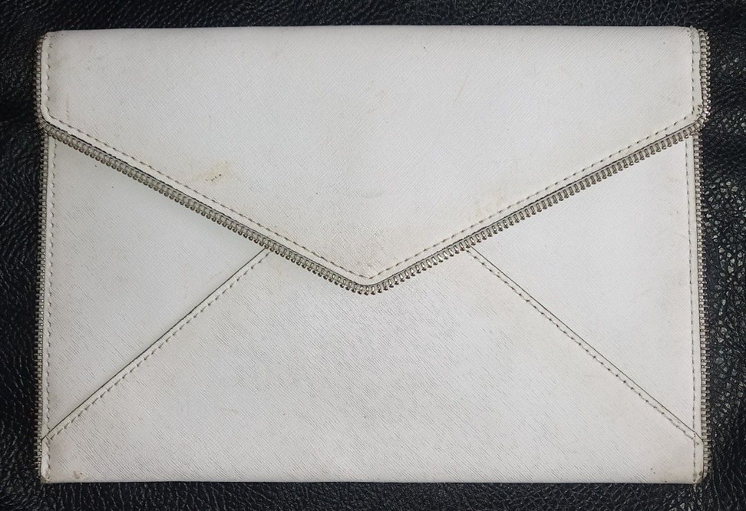 Rebecca Minkoff White Clutch (Category: Clutches) located in Cagayan de Oro. Submitted by edwardryan01984 (Listing ID 1434805733, Image 2). Description: - Rebecca Minkoff white clutch - Zipper and flap closures - Patterned interior with multiple compartments - Snap button closure - Brand name visible.