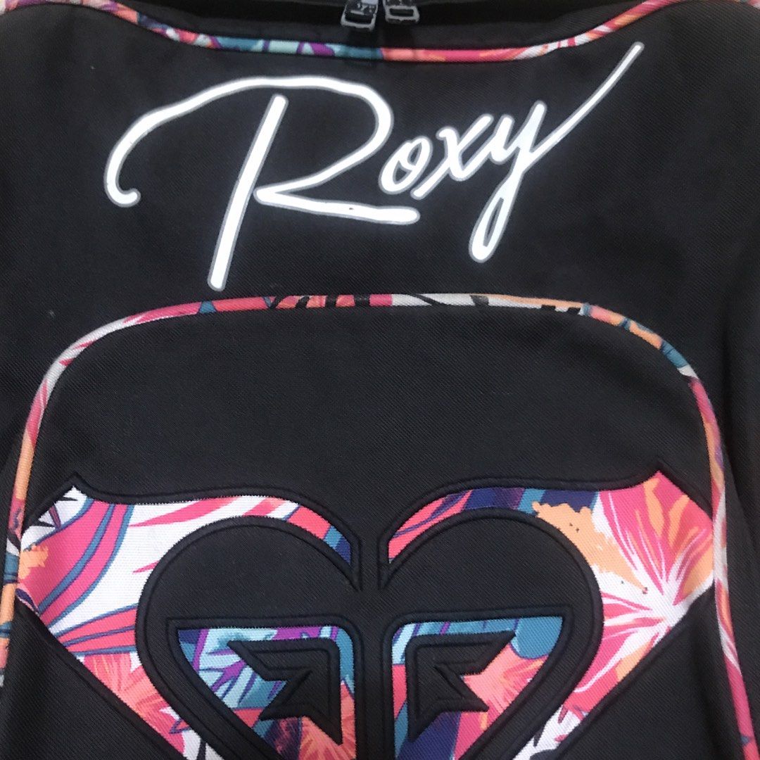Roxy Backpack Black Bag (Category: Backpacks) located in Imus. Submitted by alfa_8 (Listing ID 1434789472, Image 3). Description: - Roxy backpack - Waterproof - Black base with floral accents - Roxy logo on front - Adjustable straps - Top handle - Multiple compartments - Zippers Flaw - Zipper Paint.