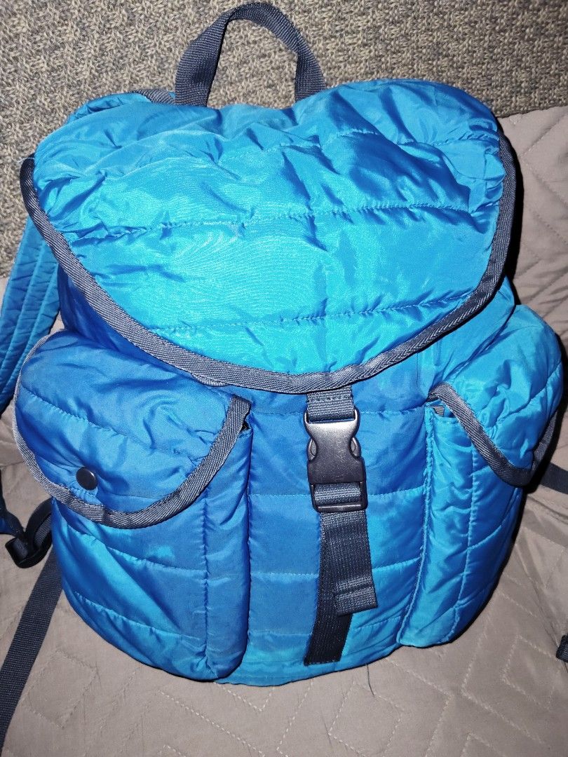 UNIQLO Quilted Backpack (Blue) - Outdoor Nylon Backpack (Category: Backpacks) located in Batangas. Submitted by kasualcornerph (Listing ID 1434691652, Image 1). Description: blue backpack with a quilted design and adjustable straps. - Color: Blue - Design: Quilting - Number of pockets: 2 front pockets - Strap: Adjustable shoulder strap - Fastening: Buckle fastening - Three interior pockets - There is a small hole (about the size of a pinhole) on 