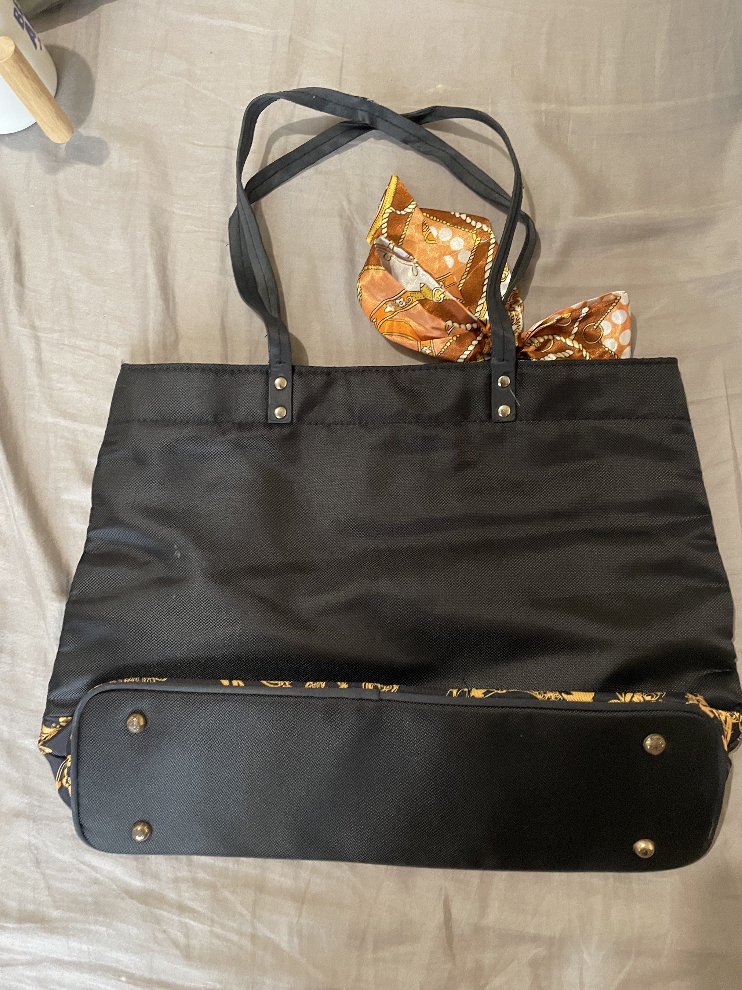 Versace Parfums Black Tote Bag (Category: Luxury Bags & Wallets) located in Santa Barbara. Submitted by frryt (Listing ID 1434603027, Image 3). Description: - Versace Parfums black tote bag - Gold Versace logo on front - Gold and black patterned accents - Includes matching scarf - Interior features gold and black Versace pattern - Zippered pocket with Versace Parfums zipper pull.