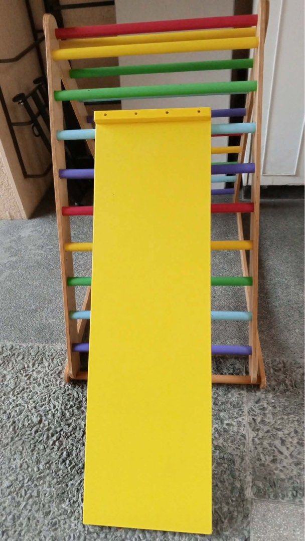 Wooden Climbing Triangle with Slide (Large Pickler) (Category: Infant Playtime) located in Paranaque City. Submitted by beagarciachoy (Listing ID 1434636415, Image 3). Description: - Wooden climbing triangle with colorful rungs. - Includes a yellow slide. - Encourages climbing and sliding for physical activity. - Improves coordination. - Sturdy and well-built frame. - Suitable for indoor and outdoor use. - Slide is easily attached and detached. -