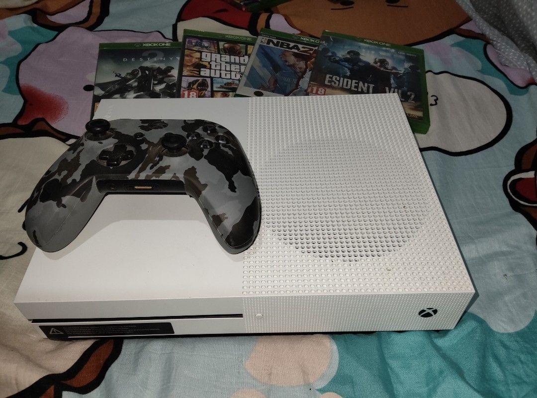 Xbox One S with Games and Controller (Category: Xbox) located in Digos. Submitted by matthewsag71344 (Listing ID 1434686929, Image 2). Description: Selling my 1tb Xbox One S (White) in very good condition. Perfect for casual and hardcore gaming! ✅ Includes: Xbox One S Console 1 Wireless Controller (Camouflage design) Power Cable & HDMI 4 Physical Games: • Destiny 2 • GRand Theft Auto V • NBA 2K22 • Resident Evil 2 30+ Digital Games -Mk11 -MKX -RD
