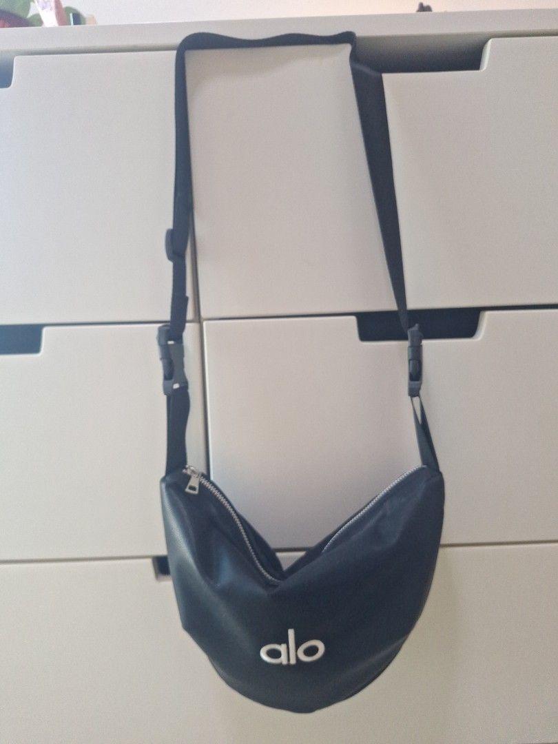 Alo Yoga Black Fanny Pack (Category: Sling Bags) located in Singapore. Submitted by favoured5 (Listing ID 1434824970, Image 2). Description: - Alo simple fanny pack in black - Soft, comfortable material - Zippered main compartment - Adjustable strap with buckle - Features the Alo logo - Ideal for carrying essentials - No wear and tear - Selling, as too many bags #Sport #Cycle #Exercise #Daily #Sling Bag .