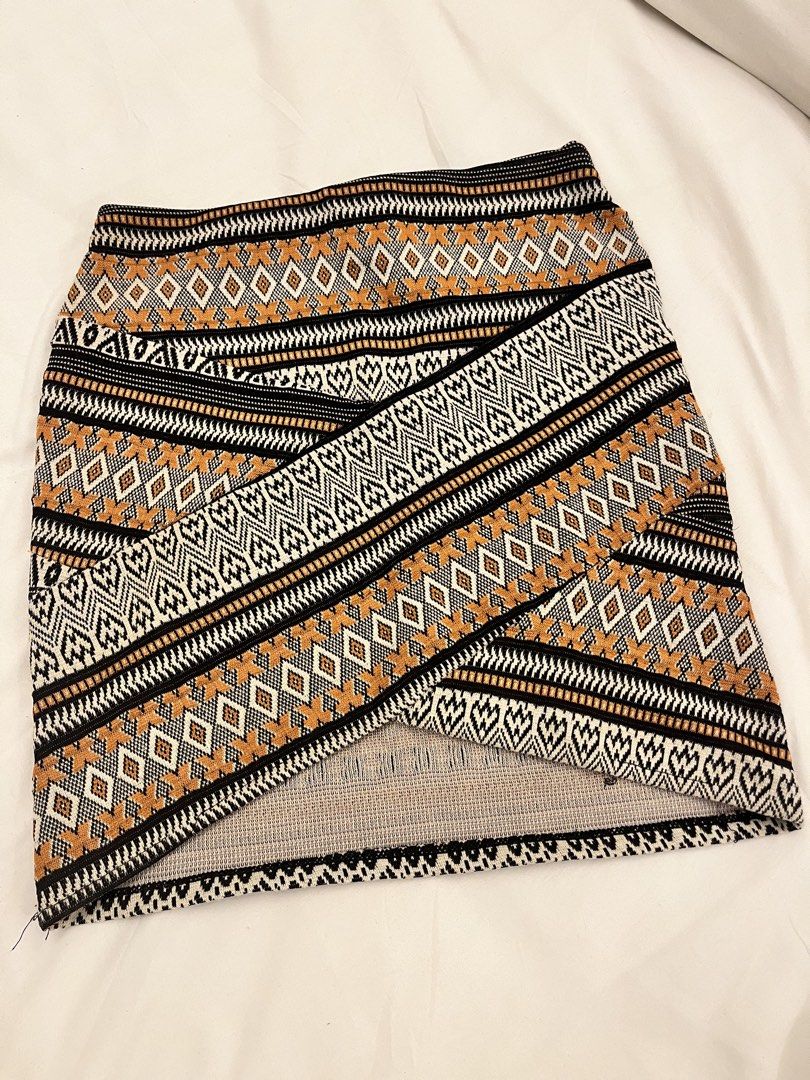 Bershka XS Skirt (Category: Skirts) located in Manila. Submitted by marianaaa0502 (Listing ID 1434927400, Image 1). Description: - Bershka skirt - Size: XS - Style: Wrap - Waistband: Black elastic - Pattern: Geometric - Colors: Black, white, and orange.