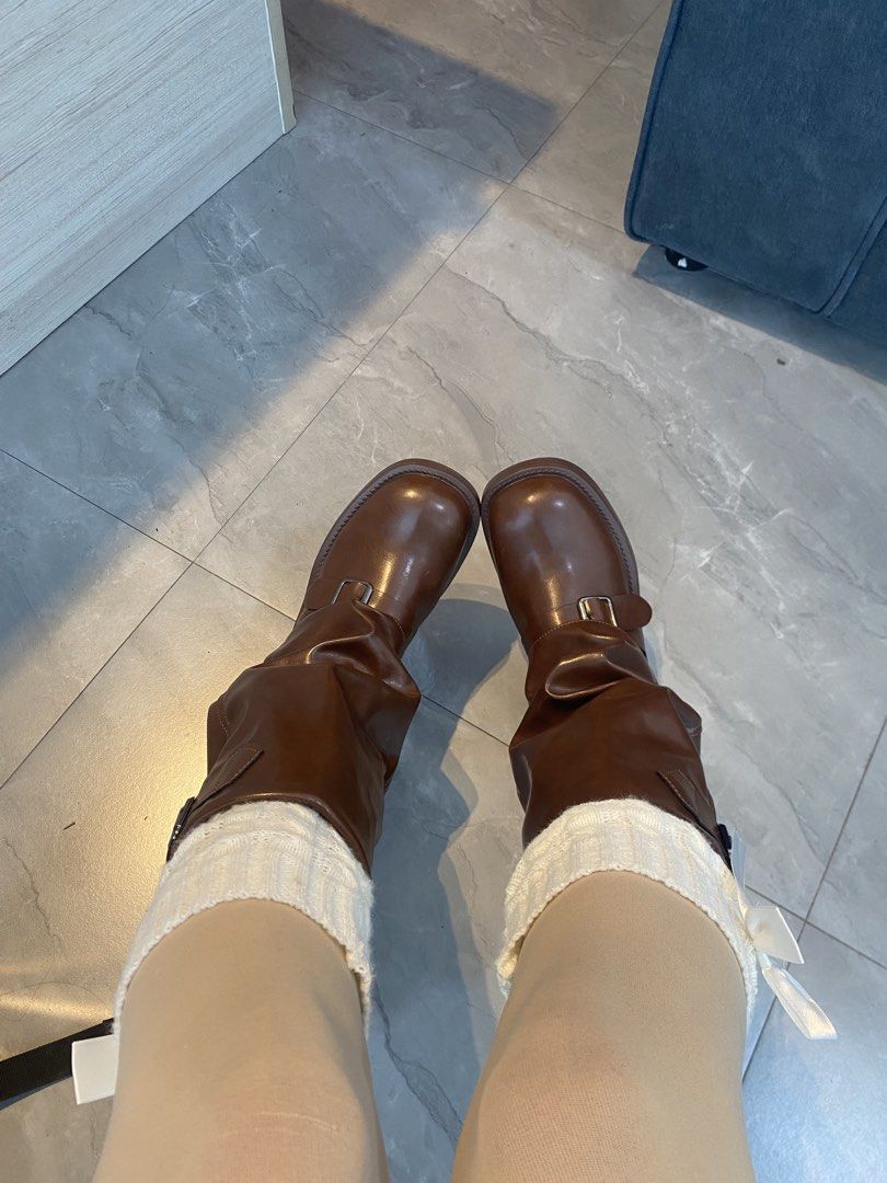 Brown Buckle Boots (Category: Boots) located in Manila. Submitted by fiercefleur (Listing ID 1434811526, Image 2). Description: Stylish brown boots with buckle details. Features a mid-calf height and a slight heel. The boots have a smooth, glossy finish. Perfect for adding a touch of edge to any outfit. The boots are shown with white socks..