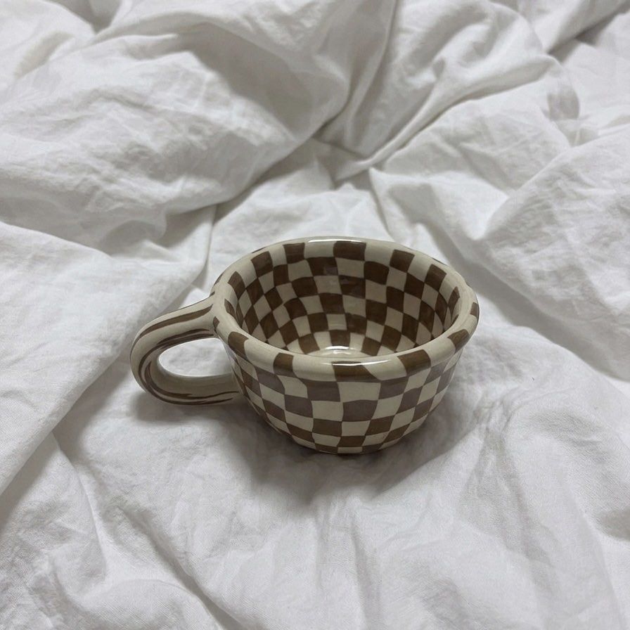 Brown Checkered Ceramic Aesthetic Coffee Mug (Category: Coffee & Tea Tableware) located in Manila. Submitted by chlo_things (Listing ID 1434950356, Image 1). Description: - Ceramic mug with a unique checkered design (brown and cream). - Comfortable handle for easy grip. - Rounded shape. - Well-crafted and stylish. - Ideal for coffee, tea, or any beverage. - A great addition to your kitchen or mug collection. 📍 Location: Quezon City (QC) 🚚 Shipp