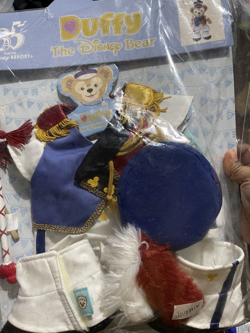 Duffy The Disney Bear Costume Set (Category: Plushies & Soft Toys) located in Muntinlupa City. Submitted by joanofarc1013 (Listing ID 1434817673, Image 1). Description: Duffy the Disney Bear costume set from Tokyo Disney Resort. The set includes a blue hat, a blue jacket, a white shirt, and other accessories. The packaging features the Duffy bear wearing the costume. It is a collectible item for Duffy fans..