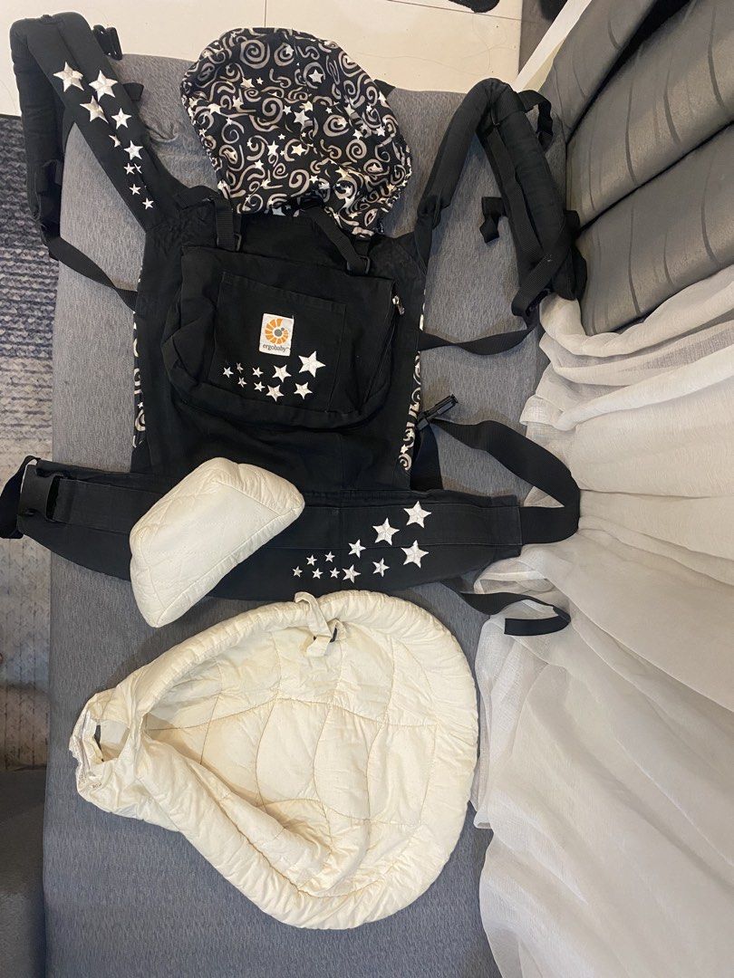 Ergobaby Baby Carrier with Infant Insert (Category: Carriers & Slings) located in Mandaluyong City. Submitted by abby_calixto (Listing ID 1434947885, Image 1). Description: - Ergobaby baby carrier - Black and white star design - Includes infant insert (cream-colored) - Suitable for newborns - Adjustable straps and buckles - Features a hood.