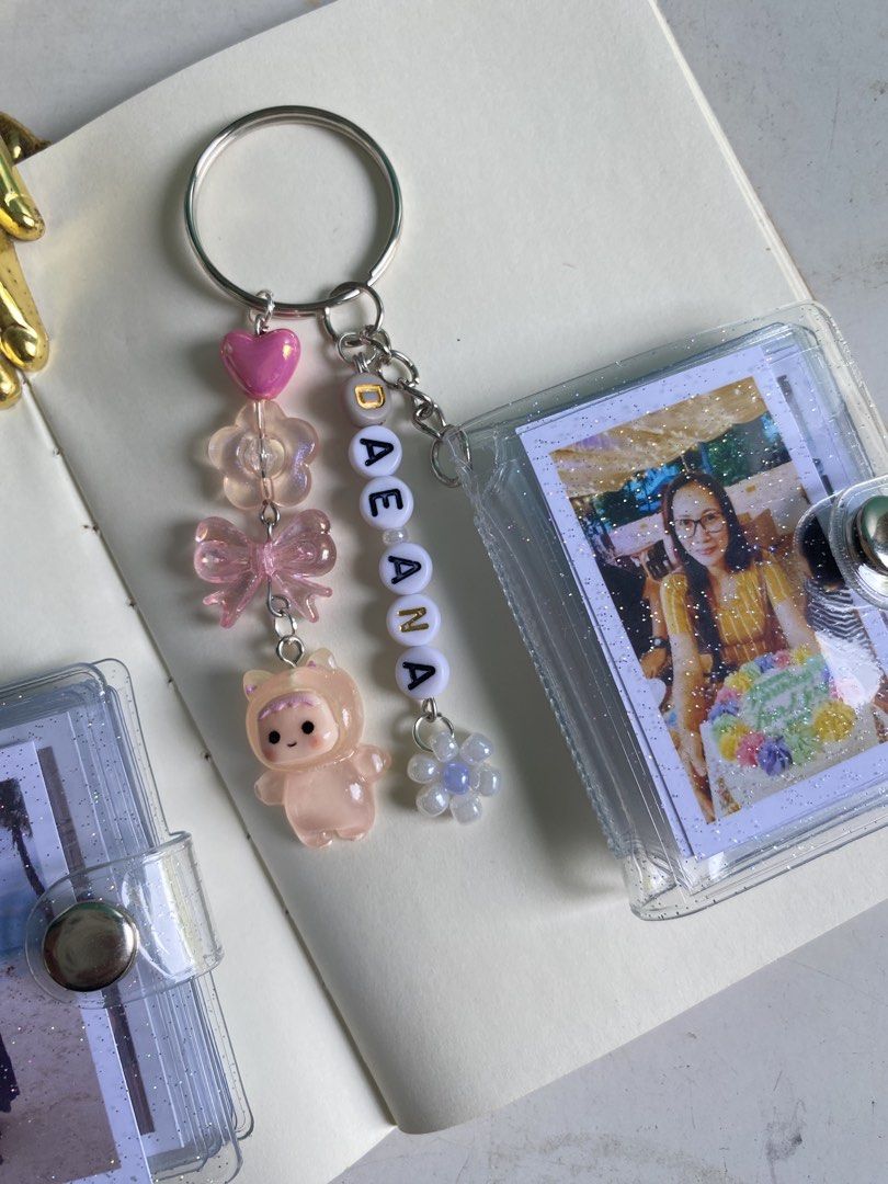 Handmade Mini Photo Album Keychain (Category: Handmade Craft) located in Lapu Lapu. Submitted by ayith_journals (Listing ID 1434895532, Image 3). Description: - Handmade mini photo album keychain - Holds multiple photos - Personalized with beads, charms, and name beads - Available in various designs and colors - Perfect for a unique and personalized accessory or gift.