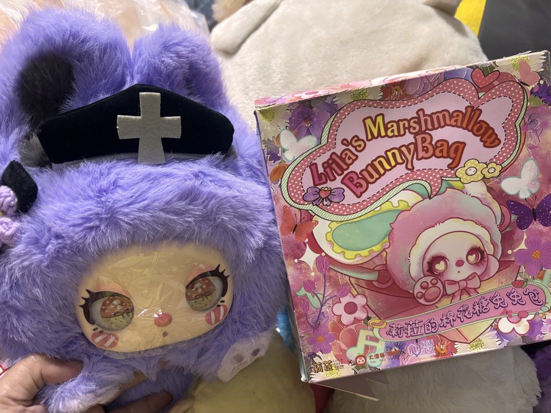 Liila's Marshmallow Bunny Bag (Category: Luxury Bags & Wallets) located in Manila. Submitted by kathylandia (Listing ID 1434994316, Image 3). Description: - Lila's Marshmallow Bunny Bag - Adorable fluffy purple bunny design - Features a cute bunny face and nurse hat - Includes matching strap and box - Brand new, still in original packaging.