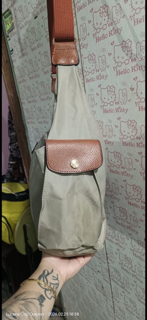 Longchamp Shoulder Bag (Category: Luxury Bags & Wallets) located in Manila. Submitted by _outofthecloset. (Listing ID 1434926573, Image 2). Description: - Authentic Longchamp shoulder bag - Beige nylon exterior with brown leather accents - Single shoulder strap - Front pocket with flap closure - White fabric interior lining - Includes Longchamp logo patch - Made in France - ISSUE MIN. SLICE .