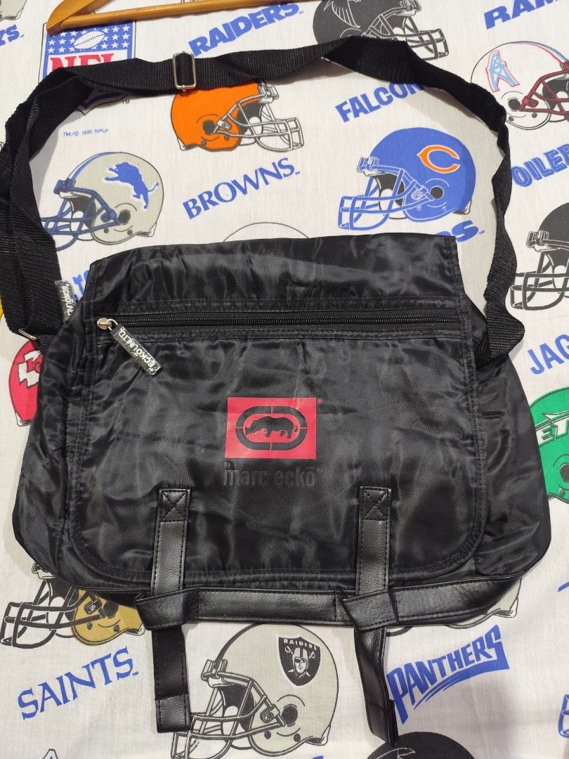 Marc Ecko Black Collapsible Messenger Bag 14”x11” New (Category: Sling Bags) located in Baguio. Submitted by FRANKLIN (Listing ID 1434908116, Image 2). Description: The Marc Ecko Black Collapsible Messenger Bag is a stylish and practical accessory for men. With a solid black color and logo character, this medium-sized bag features adjustable straps for added convenience. The synthetic lining and material provide durability, making it suitable for