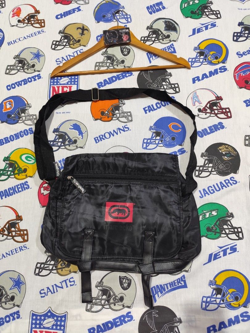 Marc Ecko Black Collapsible Messenger Bag 14”x11” New (Category: Sling Bags) located in Baguio. Submitted by FRANKLIN (Listing ID 1434908116, Image 1). Description: The Marc Ecko Black Collapsible Messenger Bag is a stylish and practical accessory for men. With a solid black color and logo character, this medium-sized bag features adjustable straps for added convenience. The synthetic lining and material provide durability, making it suitable for