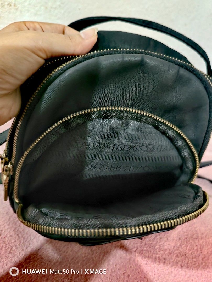 Prada Black Teddy Bear nylon Backpack (Category: Luxury Bags & Wallets) located in Villasis. Submitted by mysticforest.bb2b4b (Listing ID 1434895676, Image 3). Description: - Black backpack with teddy bear design - Multiple zippered compartments - Top handle - Detachable strap for shoulder or crossbody wear - Prada branded interior - Gold-toned zippers.