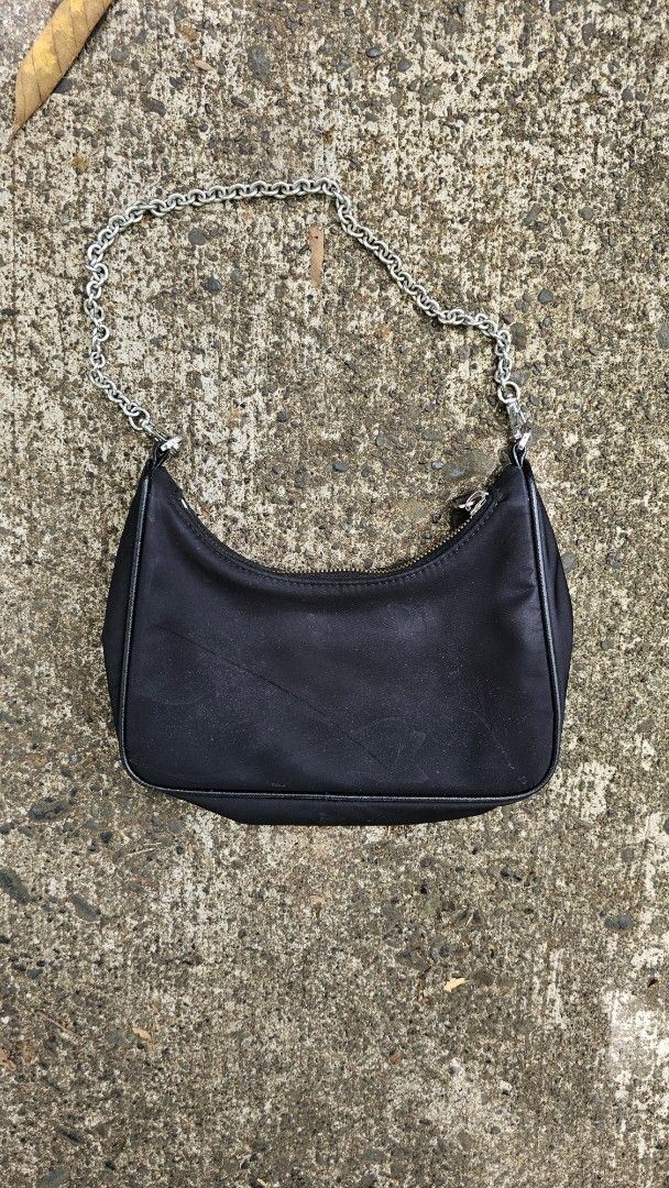 Prada Re-Edition 2000 Mini Bag (Category: Luxury Bags & Wallets) located in Kibawe. Submitted by Thrift_ni_Babac (Listing ID 1434945283, Image 2). Description: - Prada Re-Edition 2000 mini bag - Color: Black - Material: Nylon - Strap: Silver chain - Closure: Zip with Prada logo - Features Prada logo on front - Interior: Prada Milano label Excellent Condition.