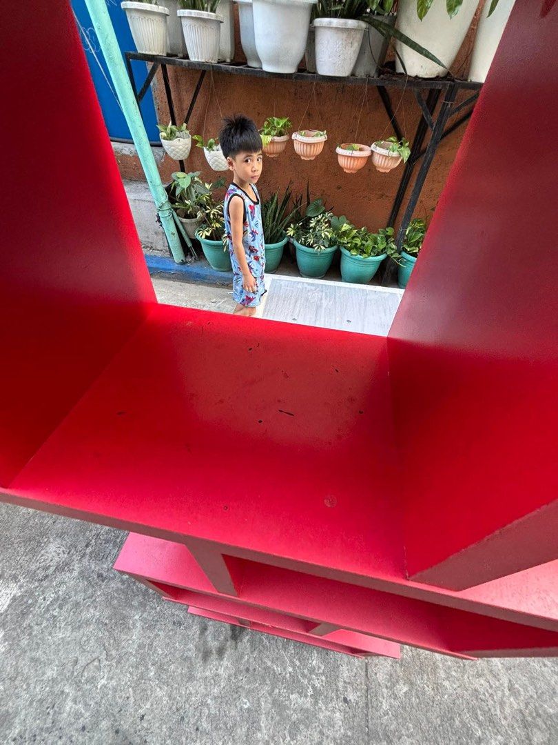 Red Wooden Accent Display Rack/Bookshelf (Category: Shelves, Cabinets & Racks) located in Manila. Submitted by offtherack_mnl (Listing ID 1434875833, Image 2). Description: - Vibrant red wooden bookshelf - Asymmetrical and modern design - Multiple compartments for storage - Ideal for books and decor - Adds functionality and style to your living space.