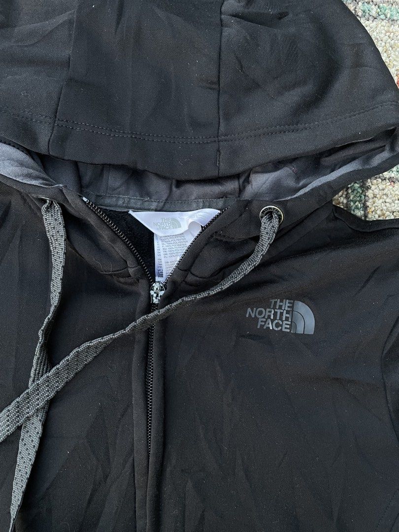 The North Face Black Hoodie Jacket (Category: Coats, Jackets and Outerwear) located in Manila. Submitted by stepsole (Listing ID 1434995575, Image 2). Description: - The North Face black hoodie jacket - Full zip closure - Hood with drawstrings - Two front pockets - The North Face logo on chest - Soft, possibly fleece-lined material -issue: slider only.