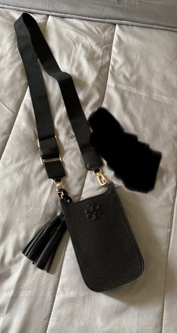 Tory Burch Phone Crossbody Bag (Category: Luxury Bags & Wallets) located in Caloocan City. Submitted by fiercestone-c8e70e (Listing ID 1434866401, Image 2). Description: - Tory Burch phone crossbody bag - Black textured leather - Embossed Tory Burch logo - Detachable crossbody strap - Stylish tassel detail - Multiple compartments for organization - Includes original packaging.